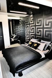 una camera da letto con un letto nero e cuscini sopra di Apartament Lema Versace a Cracovia