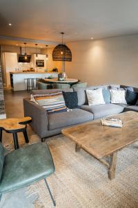 a living room with a couch and a table at Just Texel Suites & Apartments in Den Burg
