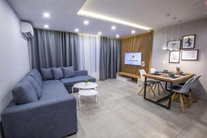 uma sala de estar com um sofá azul e uma mesa em South Place Apartments em Sandanski