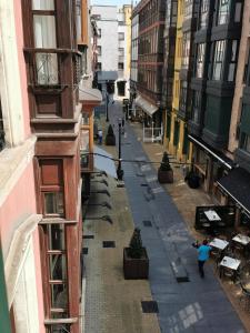 a person walking down a street between buildings at Begoña 18 Rest & Adventure in Gijón