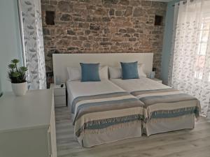 a bedroom with a large bed with a brick wall at Begoña 18 Rest & Adventure in Gijón