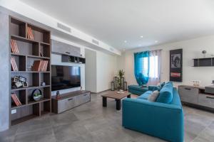 Una sala de estar con un sofá azul y un televisor. en Villa No Stress Aria di Petra, en Olmeto