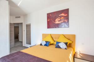 1 dormitorio con 1 cama con almohadas amarillas y azules en Villa No Stress Aria di Petra, en Olmeto 13 fotos más