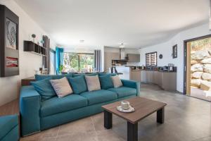 Una sala de estar con un sofá azul y una mesa. en Villa No Stress Aria di Petra, en Olmeto