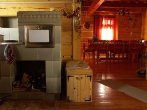 um quarto com uma lareira, uma televisão e uma sala de jantar em Dvor Magduška em Osturňa