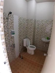 a bathroom with a shower and a toilet and a sink at Tulip Inn Tomohon in Tomohon