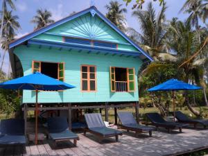 a house on the beach with chairs and umbrellas at Mutiara Beach Resort in Berakit