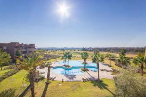 an overhead view of a swimming pool with palm trees at Vue époustouflante sur L Atlas - Prestigia in Marrakesh