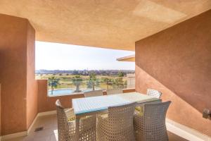 a dining room with a table and chairs and a window at Vue époustouflante sur L Atlas - Prestigia in Marrakesh