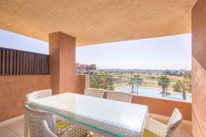 a balcony with a table and chairs and a view of the desert at Vue époustouflante sur L Atlas - Prestigia in Marrakesh