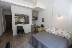 a bedroom with a bed and a table and a chair at VIP OFFICE 502 in Petrópolis