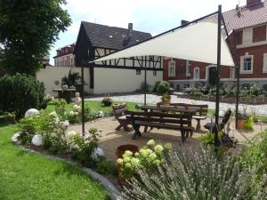 einen Garten mit einem Picknicktisch und einem Sonnenschirm in der Unterkunft Landhaus & Landhof Gabriel in Bülstringen