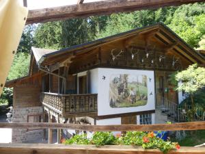 una casa con un porche y una foto en ella en Pension Holzerstube, en Beerfelden