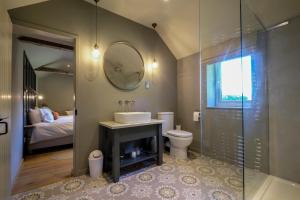 a bathroom with a sink and a toilet and a mirror at Church Farm B&B Suffolk in Great Welnetham