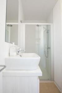 y baño blanco con lavabo y ducha. en Casara Seis o Casara Siete - Tu casa a 100m de la playa de Zahora en Zahora