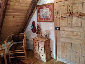 um quarto com uma porta de madeira e uma cadeira em Gite Du Bois De L'ours em Orcières