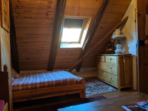 um quarto com uma cama, uma cómoda e uma janela em Gite Du Bois De L'ours em Orcières