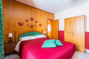 um quarto com uma cama grande e um cobertor vermelho em Locanda Farinati em Abetone