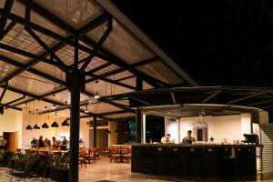 um restaurante com um bar com pessoas sentadas às mesas em Hotel Nya em Montezuma