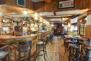 um bar com paredes de madeira e bancos num restaurante em Hotel Curracloe em Curracloe