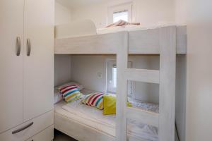 a white bunk bed with two pillows in a room at Matorin Floatinghouses in Portorož