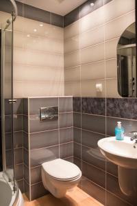 a bathroom with a toilet and a sink at Hotel Hensch in Łódź