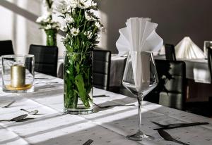 un tavolo con un vaso di fiori su un tavolo di Hotel Hensch a Łódź