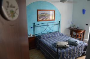 a bedroom with a bed with a blue wall at Tra... Monti E Vigne in La Morra +51 photos
