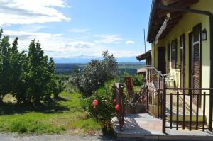 a yellow house with a gate and a balcony at Tra... Monti E Vigne in La Morra