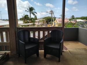 two chairs on a balcony with a view of a city at Marilyn Appartments in Kralendijk