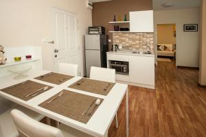 a kitchen with a white table and white chairs at The Trust Condo Huahin Soi5 in Hua Hin