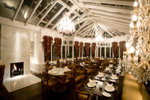 a dining room with tables and chairs and a chandelier at Fines Bayliwick Hotel in Bracknell