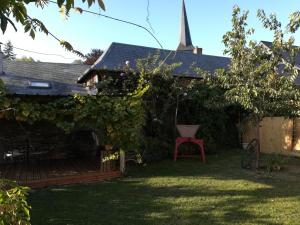 ein Haus mit einem roten Stuhl im Hof in der Unterkunft Chez Flo in Ry