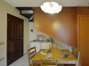 een keuken met een houten tafel met stoelen en een licht bij IL Cinquecento in Napels