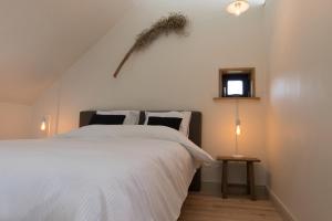a bedroom with a white bed and a window at Atelier Botanie luxury short stay apartment in Hasselt