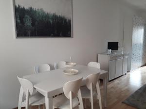 a white dining room with a white table and chairs at Ypsibloom in Castelbuono