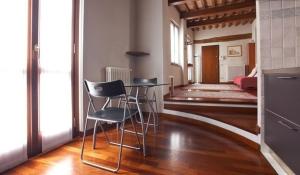 Habitación con 2 sillas, mesa y sala de estar. en The Diamond Flat, en Parma