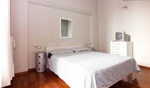 a bedroom with a white bed and a tv at The Diamond Flat in Parma