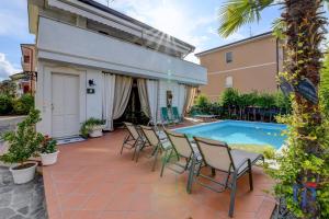 a patio with a table and chairs next to a swimming pool at DesenzanoLoft Casa Annamaria in Desenzano del Garda