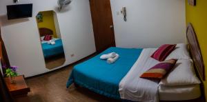 リマにあるTupac Lima Airportのベッドルーム1室(青いシーツと鏡付きのベッド1台付)