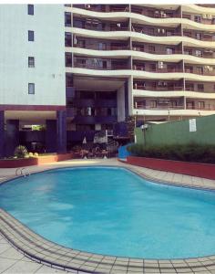 a large swimming pool in front of a large building at Porto de Iracema Residence in Fortaleza