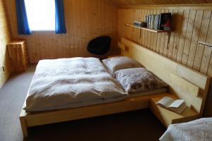 a bedroom with two beds and a chair in it at Chata Brigit in Vrbno pod Pradědem