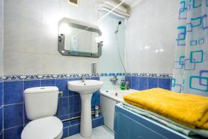 a blue and white bathroom with a sink and a toilet at Квартира на Соборной in Mykolaiv