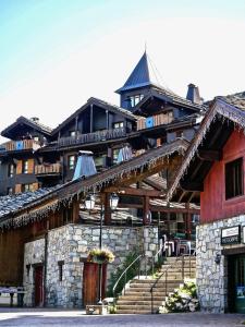 a large building with stairs in front of it at Arc 1950 Manoir Savoie Skis aux pieds in Bourg-Saint-Maurice