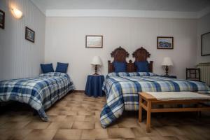a bedroom with two beds and a table in it at I Quattro Grappoli in Neive