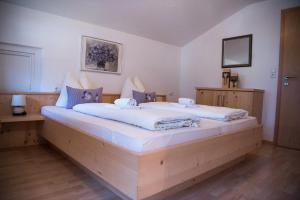 1 dormitorio con 1 cama grande con sábanas blancas en Appartements Spitaler, en Ried im Zillertal