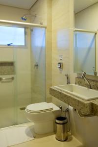 a bathroom with a toilet, sink, and shower at Lindóya Hotel in Catalão