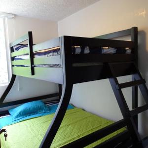 two bunk beds in a room with a green bed at Jaco Beach Condos in Jacó