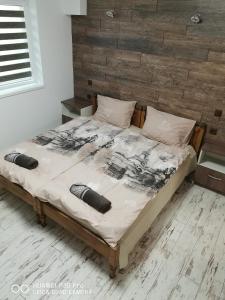 a bedroom with a large bed with a wooden headboard at Hotel Belisimo in Ruse