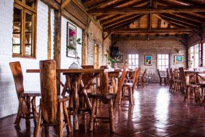 une salle à manger avec des tables et des chaises en bois dans l'établissement La Casa del colibri ecuador, à Quito